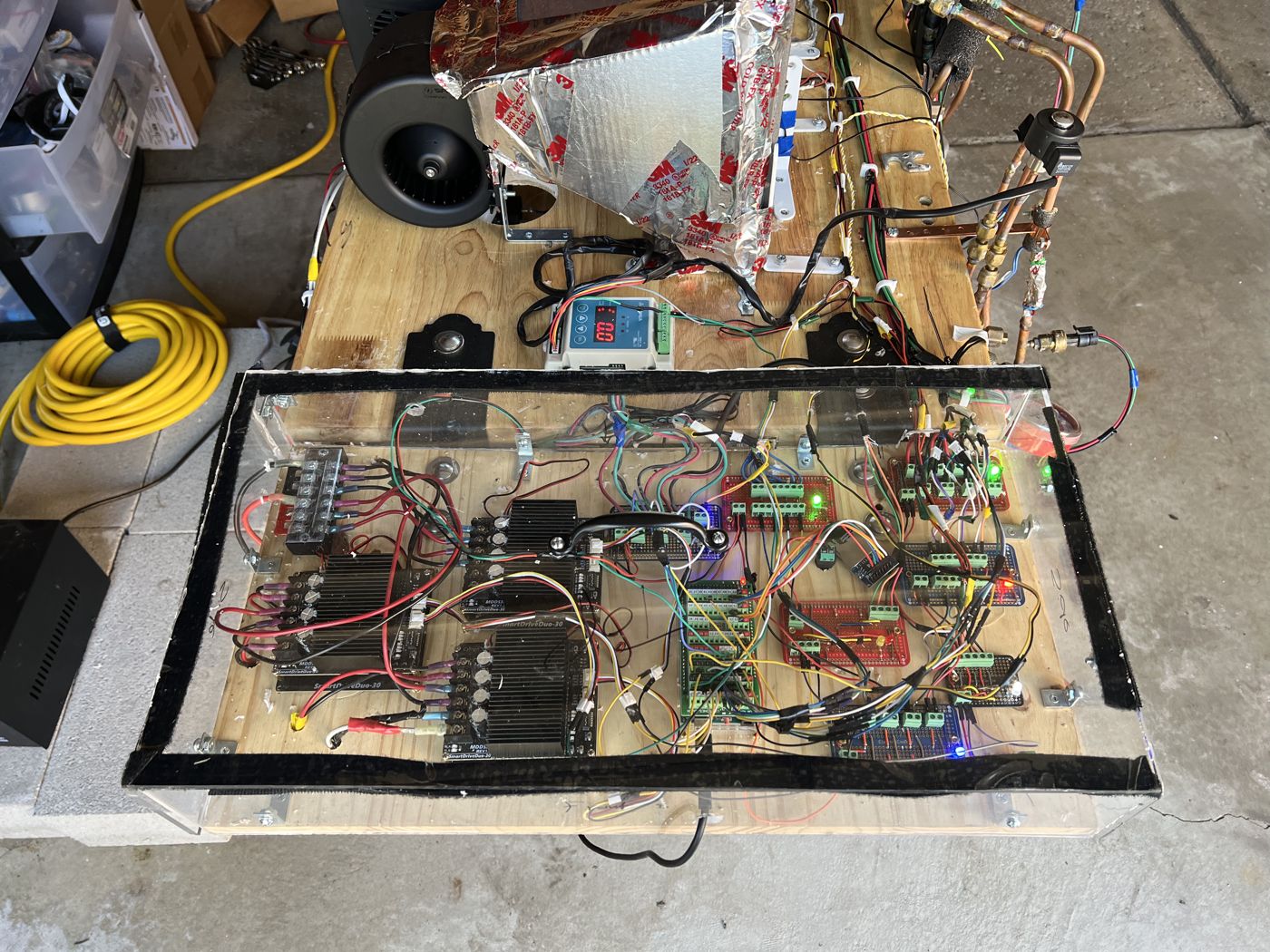 Top view of the controller box: motor drivers, terminal boards and hand-routed wiring under a clear acrylic cover
