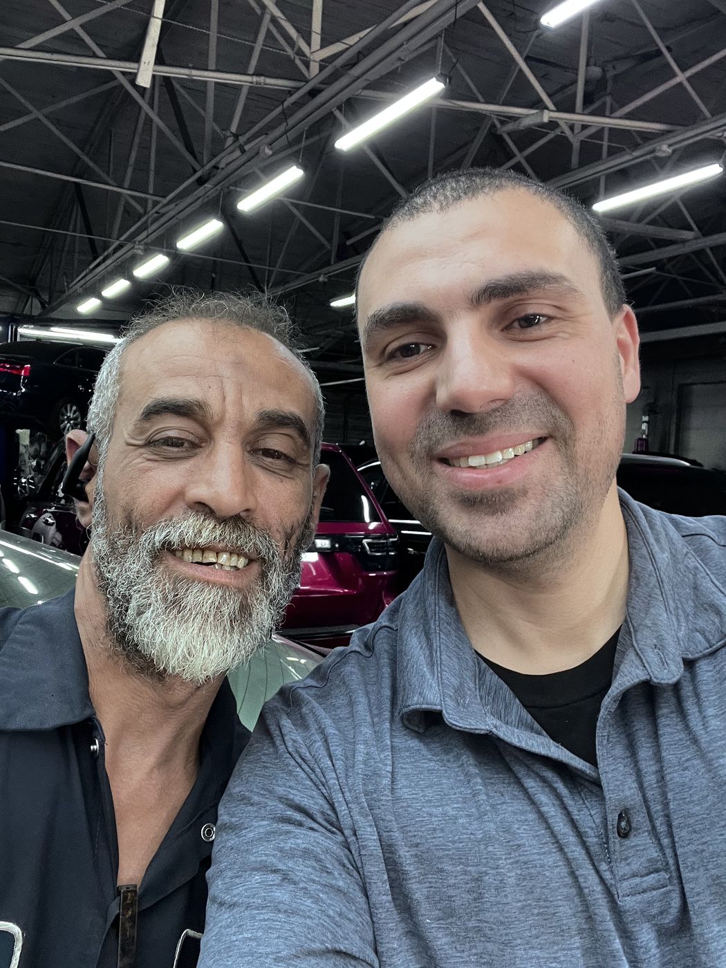 Ahmed and Badani smiling together in Badani's repair shop